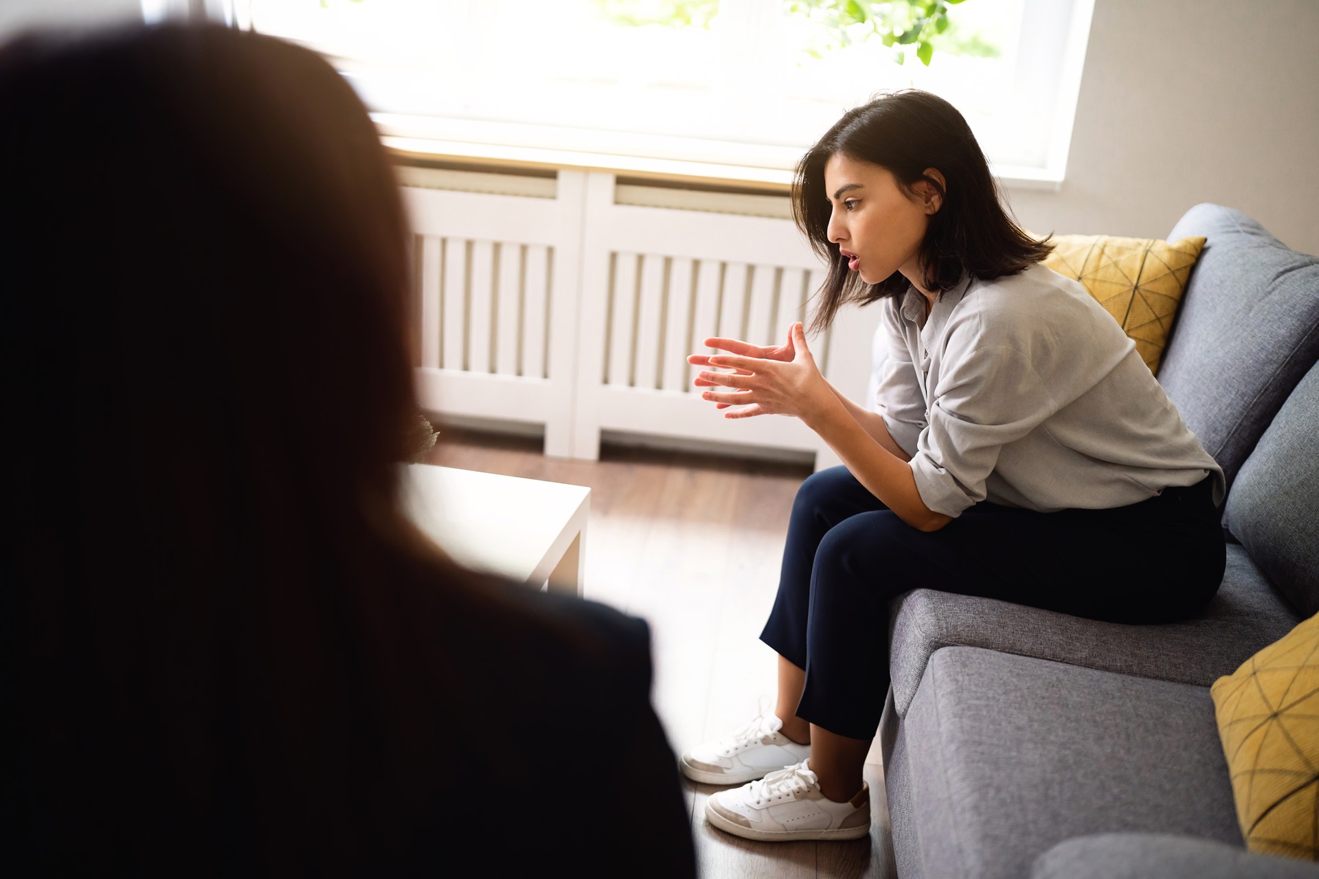 Young woman sharing her thoughts and emotion at the therapy