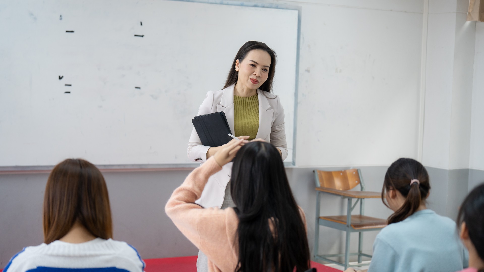 A woman is teaching a class of students