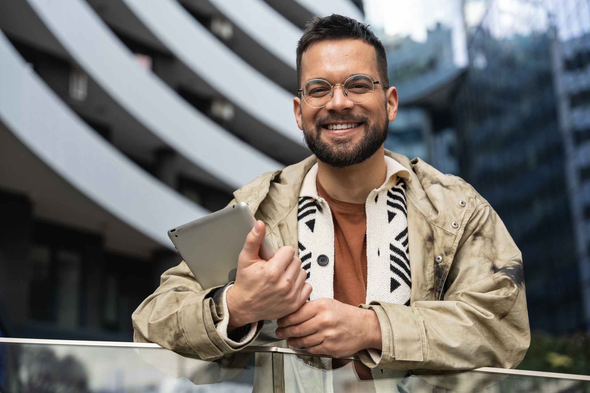 Young independent hipster businessman freelance motivational speaker life coach standing in front of office building preparing for staff meeting. Businessperson product strategy expert waiting